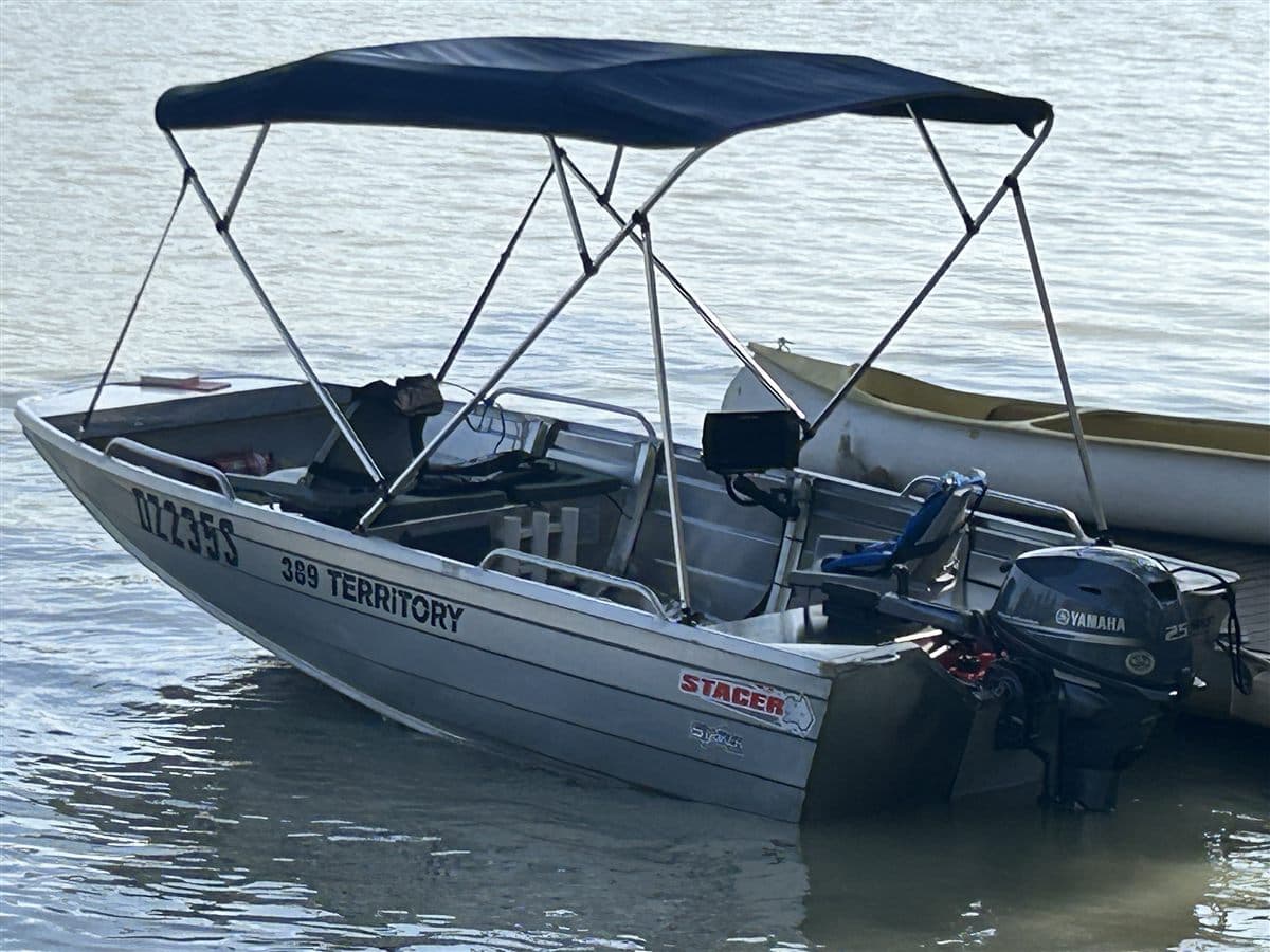 A Stacer Territory hire tinny on the water, showing its bimini, sounder and 25 hp Yamaha outboard