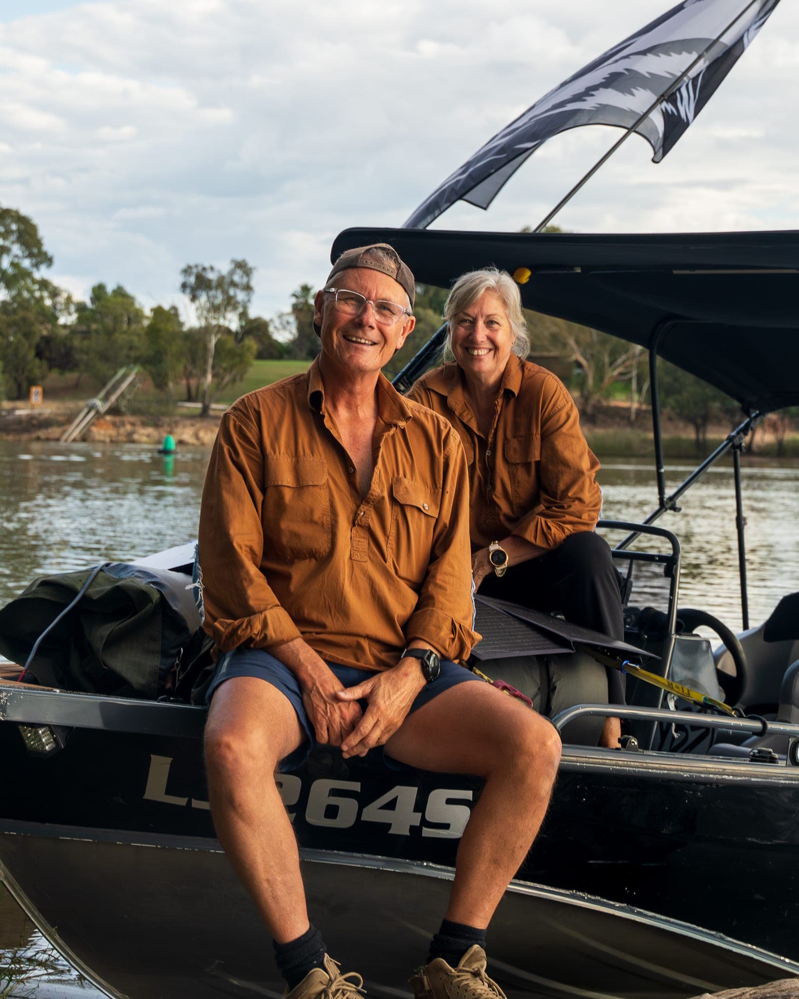Justin sitting on the bow of the tinny with Cathy behind him, pulled up on the bank of the Murray River